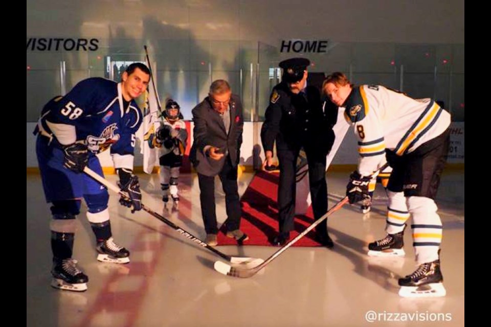 The Temiscaming Titans' Jericho Mongrain, left, and the Bradford Rattlers' Jesper Eriksson pose during the ceremonial puck drop Oct. 30. Dropping the pucks were Bradford mayor-elect James Leduc, second from left, and Bradford's acting fire chief, Ian Poot.