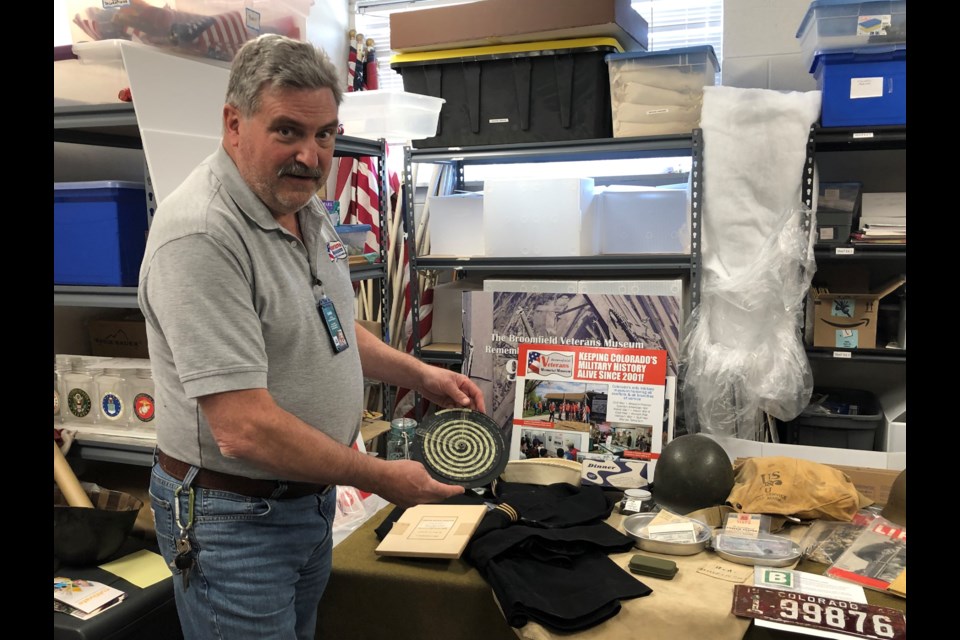 David Little holds up a circular slide rule that was used to calculate location by pilots. 