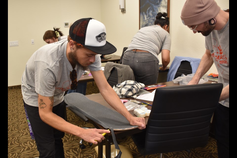 Volunteers with retailer Journeys built skateboards on Tuesday that were donated to kids at the Hidden Lake Boys & Girls Club.