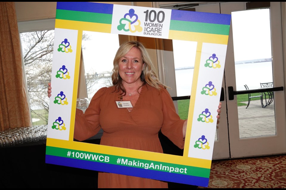 Carmelle Krasevec holds the selfie sign at the April meeting of 100 Women Who Care Burlington on Wednesday night at the Burlington Golf and Country Club.