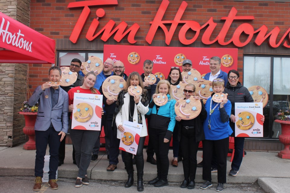 Tim Hortons staff and Burlington Food Bank staff and volunteers are joined Mayor Marianne Meed Ward  (in white jacket) and Ward 1 Coun. Kelvin Galbraith (left) for the launch of the Smile Cookie campaign at the Plains Road West restaurant May 1. 