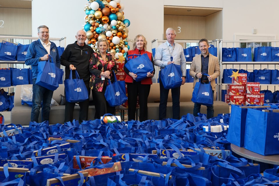 Surrounded by 687 bags of donated items that will go to the Gift of Giving Back partner agencies are (from left): Robin Bailey, John Crick, Kim Lindsay, Laura Foster Oros, JBH president and chief executive officer Eric Vandewall and Ward 1 councillor Kelvin Galbraith.