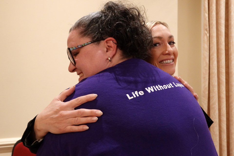 Lupus Ontario vice-president Lisa Bilodeau (100WWCB facilitator) gets a hug from Jennifer Rayworth after the funding announcement.