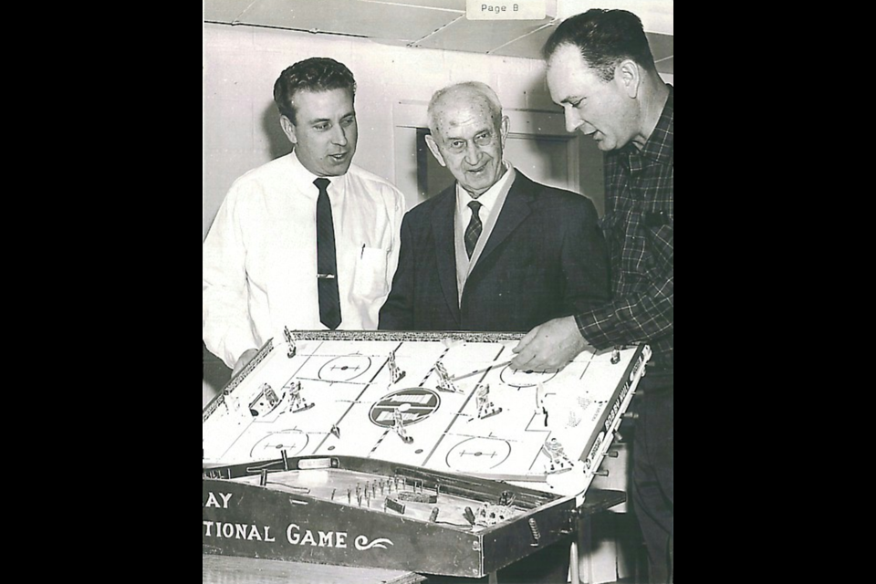 (Left to right) Donald H. Munro Jr-Donald H. Munro Sr. and William H. Munro, with one of the company's table top hockey games.