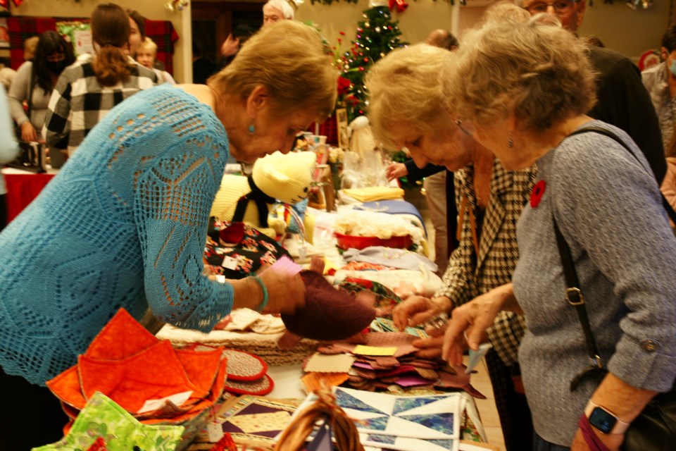 Left to right: Angela, Stephanie and Mary Lou check out some of the items on offer at the Bell Bazaar at Holy Rosary Church Nov. 5.