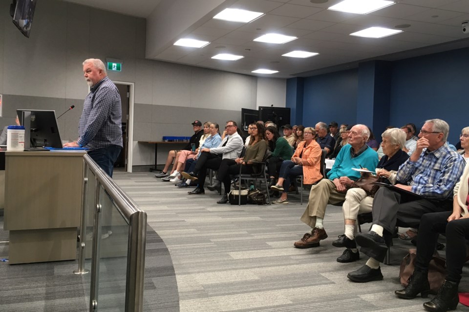 Gord Pinard of CORE Burlington speaks during the Sept. 18 planning committee meeting as members of the packed audience look on.