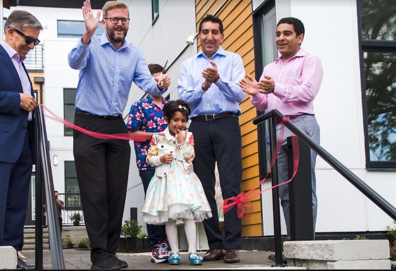 Mayor Jonathan Cote (waving) joined Canada West Group represenatives and Elina (the developer's daughter) at the opening of Elina on Eighth.