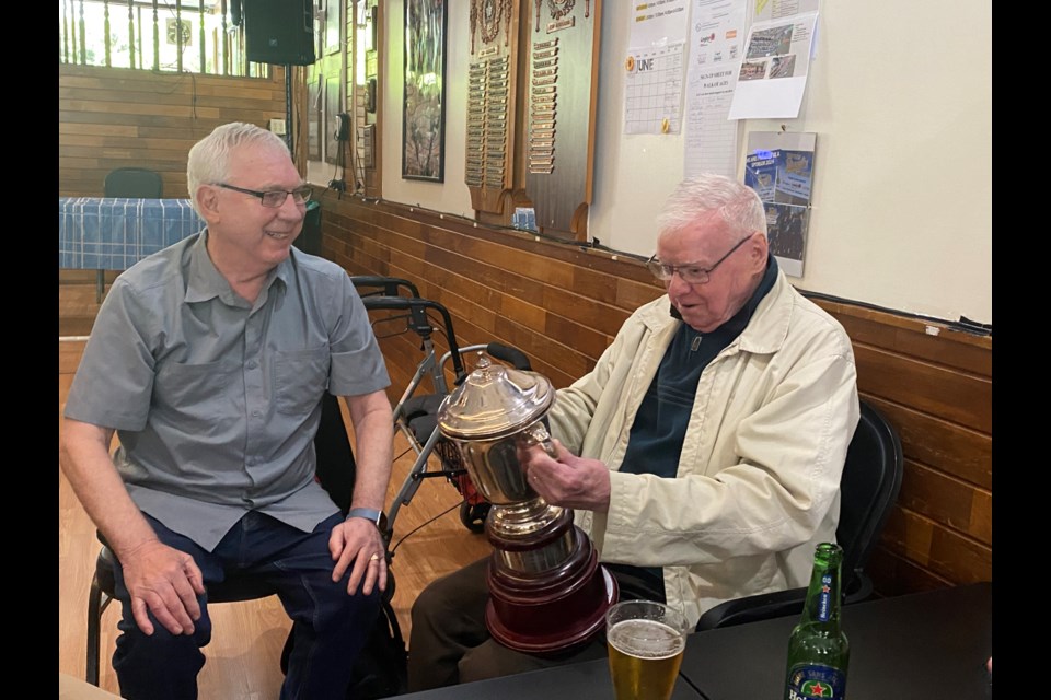 New West resident John Murray, right, checks out the Provincial Cup trophy, while Geoff McCormick looks on.