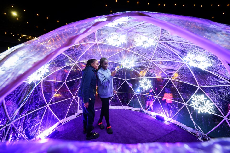 Lumi Amosu, right, and Remi Olowo in a giant snow globe at the Dec. 15 Snowflake Spectacular event.