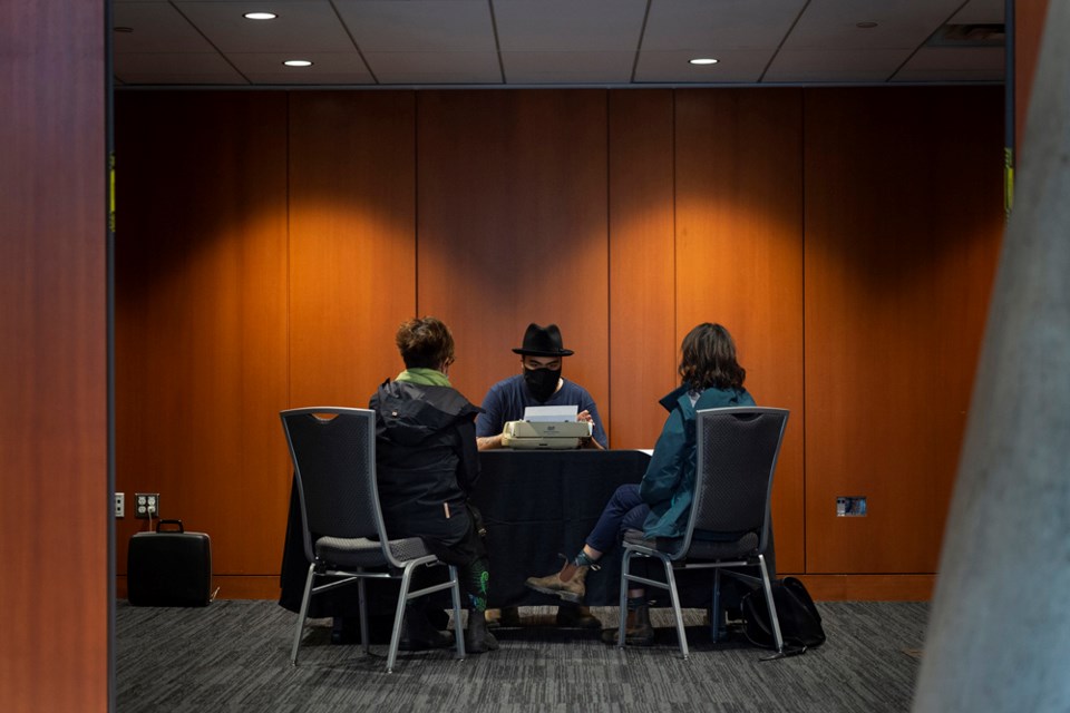 New West poet laureate Elliott Slinn writes "on-the-spot" poetry for Alison Green and Quyen Hoang at the Anvil Centre as a part of New West Cultural Crawl.