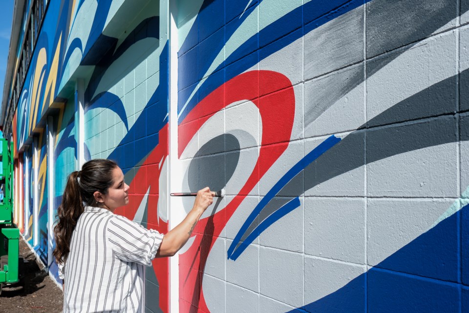 Kelly Cannell, a Musqueam artist, paints "Keepers of the Land" at BCIT for Vancouver Mural Festival.