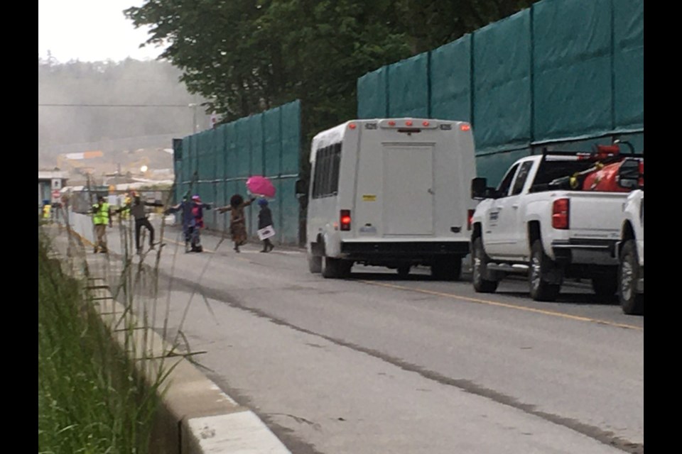 It seems some early morning disco-themed dog walkers taking the Burnaby Mountain trail are all using the pedestrian crosswalks at the same time and making it difficult for work trucks and equipment to enter the gates of the Trans Mountain worksite.