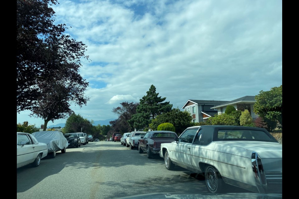 Cadillacs line both sides of the street.