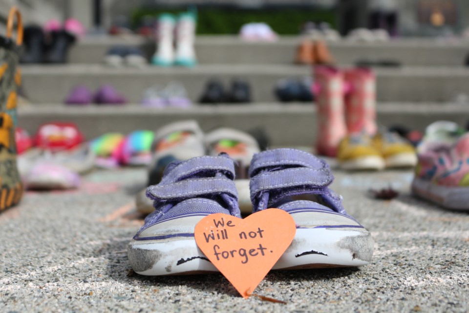 A display of children's shoes on the steps in front of the New Westminster cenotaph pays tribute to the 215 children whose bodies were found last week on the grounds of the former Kamloops Indian Residential School.