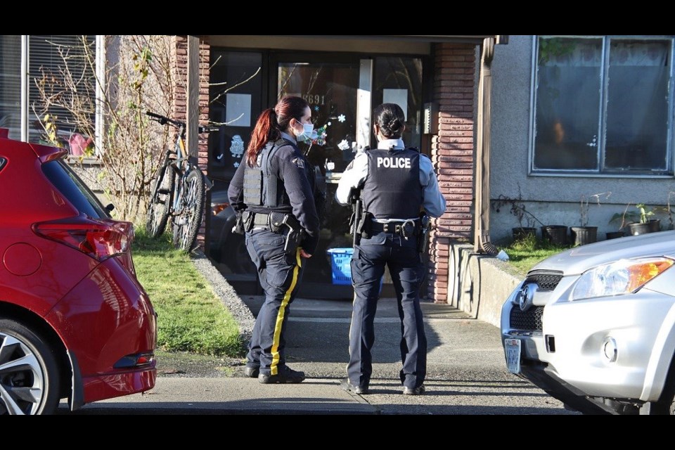 Officers surrounding an apartment on Dow Street Sunday looking for a suspect in a stabbing at Metrotown mall.