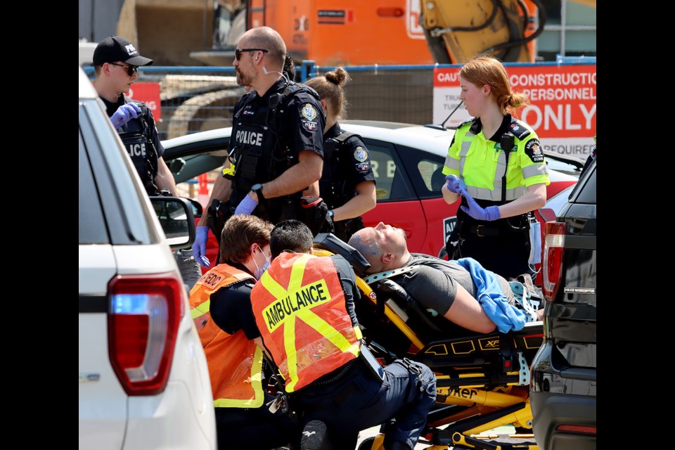 Paramedics secure a person involved in an uptown police to a stretcher. Police boxed in a Royal City Taxi vehicle at the corner of Sixth Street and Seventh Avenue Wednesday afternoon (May 17).