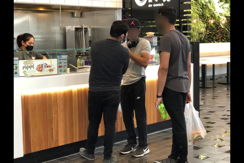 Two out of these three young men were not wearing a mask or wearing it improperly in violation of COVID-19 rules.