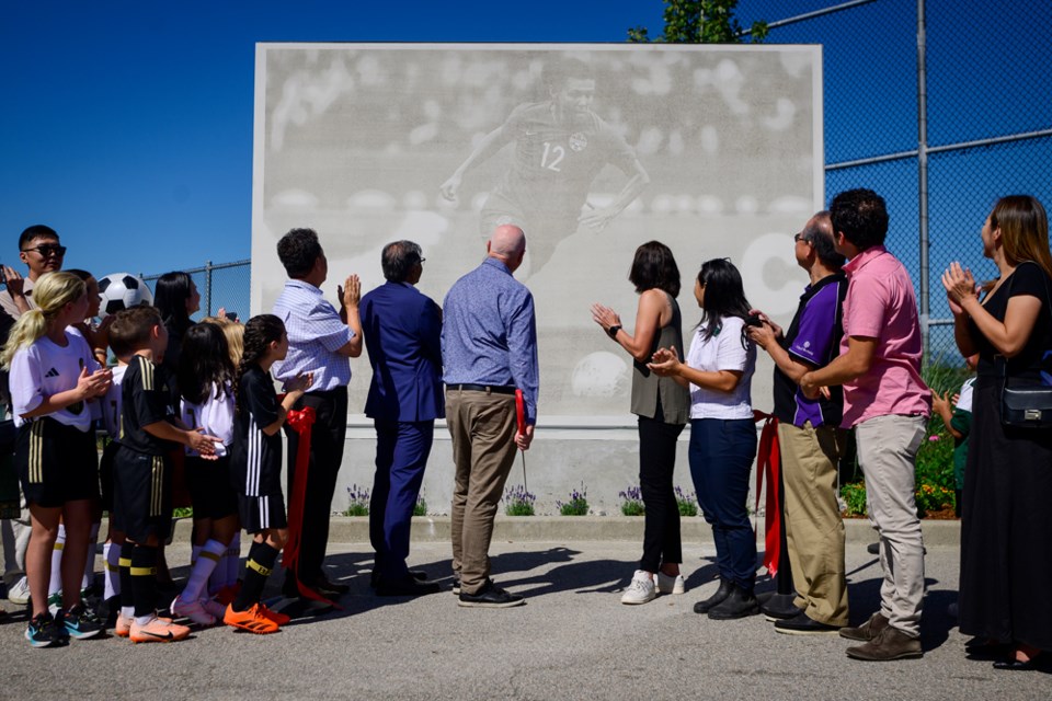 Christine Sinclair reacts to the unveiling of a dedication wall.