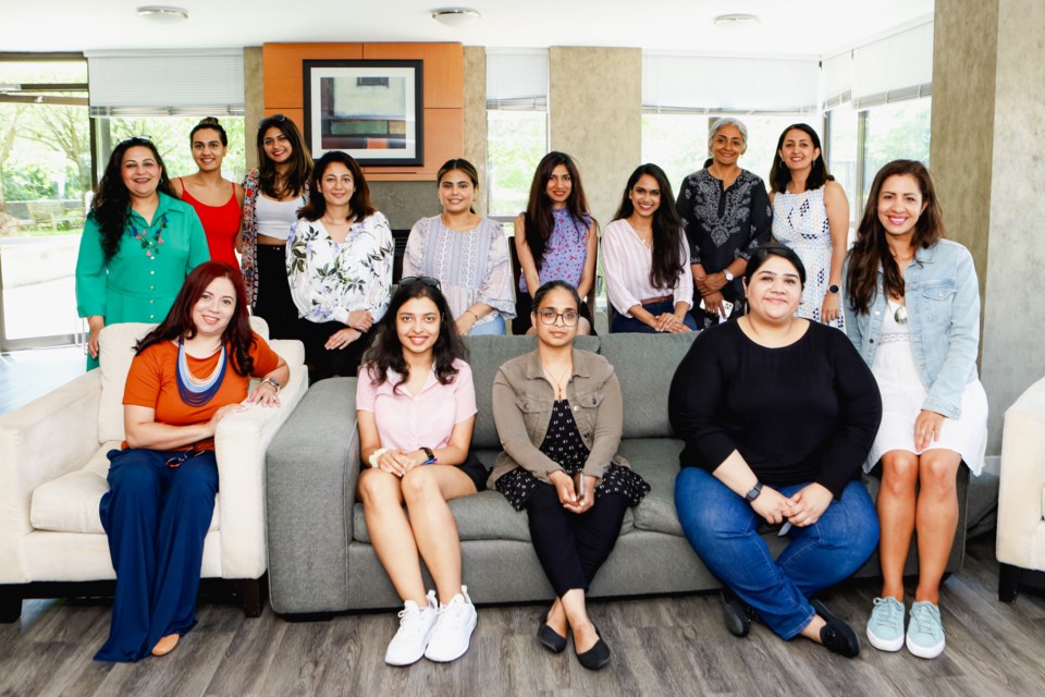 Tina Balachandran (left — pictured in green) and Prachi Jatania (second from right — pictured standing in white) create community for immigrant women to empower them in their career journeys in Canada.