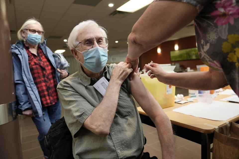 Cathy and Alex Burton get their COVID-19 vaccines at a clinic at Douglas College in New Westminster.