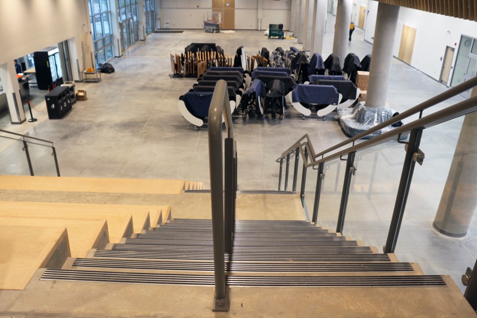 The main-level Grand Commons – seen here looking down from the second-floor mezzanine – will be the first space visitors enter coming in through the main school doors. The open area has access to the Servery and will have reconfigurable furniture. The Grand Commons will also be available as a separate rental space for meetings, conventions and events. (From this view, the main doors are out of sight to the right; at top left are doors to an outdoor plaza area at the back of the school.)