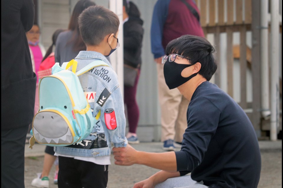 Dad Zongjian Cao prepares to send his son Bolin off to his first full day of Grade 1 at Maywood Community School Wednesday. 