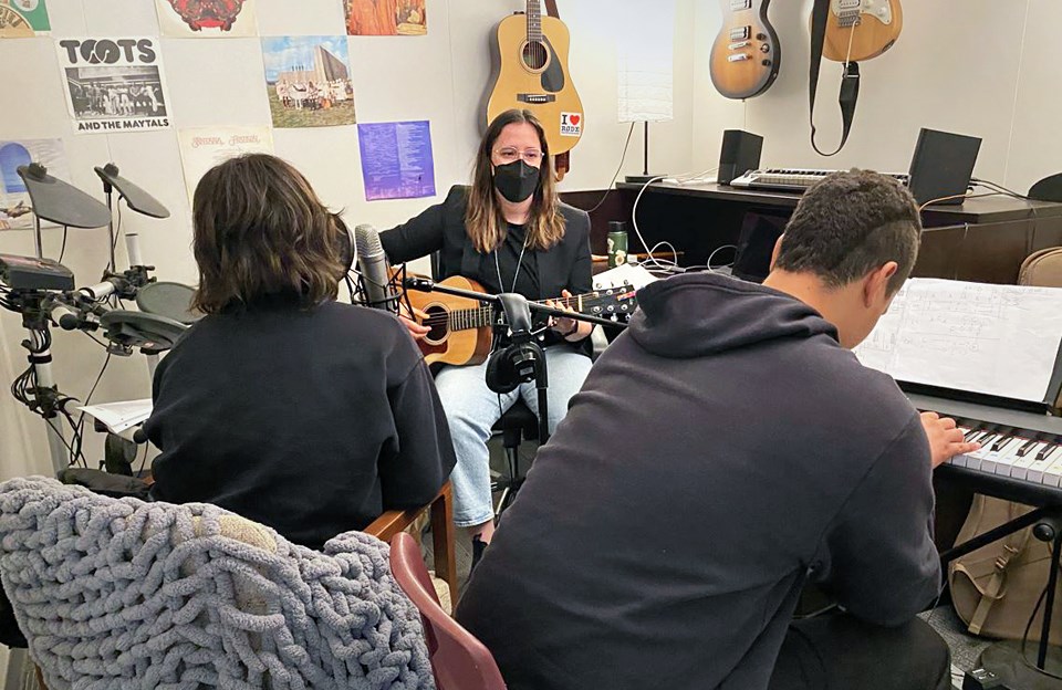 Music therapist Felicia Wall leads two alternate education students in a session.. 