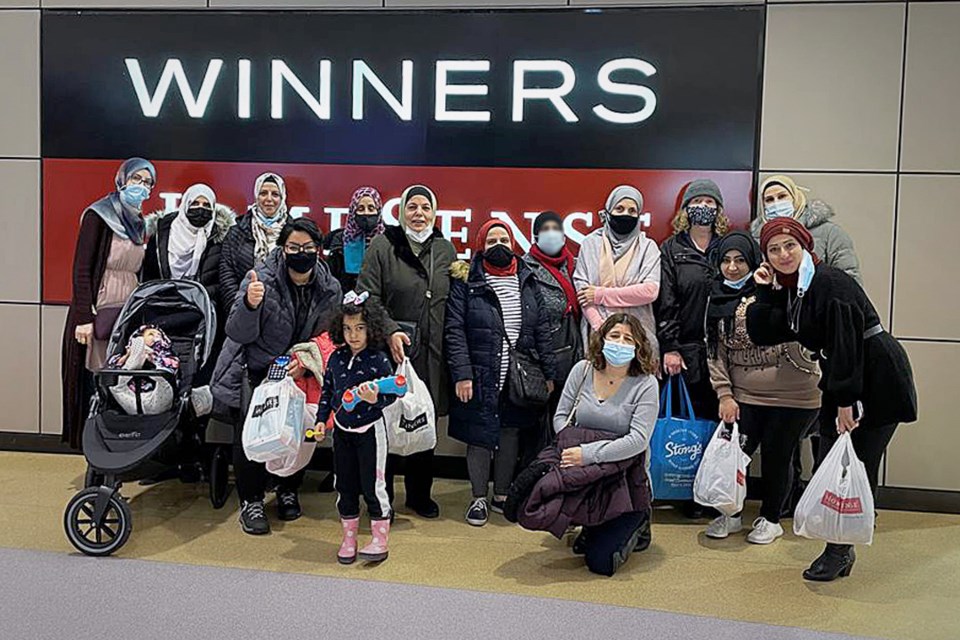 A group of Arabic-speaking women refugees pose for a photo during a holiday shopping trip arranged by school settlement workers recently. 