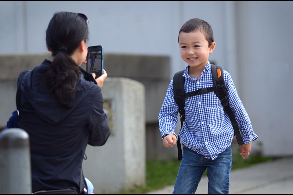 Mom Sherry Zhu snaps a photo of son Andrew Anderson on his first day of kindergarten at Taylor Park Elementary Wednesday.