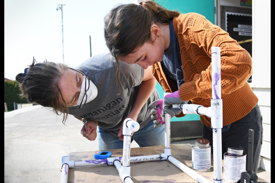 Sperling Elementary School Grade 6 and 7 teacher Gillian Potyka helps student Vie Montgomery glue together part of a pvc submersible.