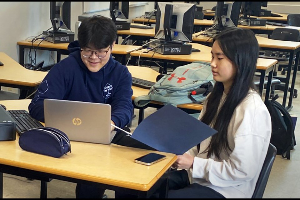 Burnaby Mountain Secondary students Joshua Jung and Naomi Foo work on a fellow high school student's taxes at a free tax clinic in April. 