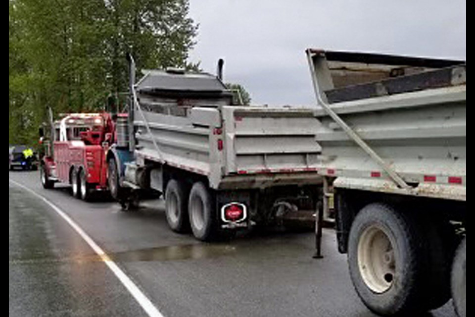 A dump truck and trailer are towed from Marine Way in Burnaby after police took it out of service for safety violations Monday.