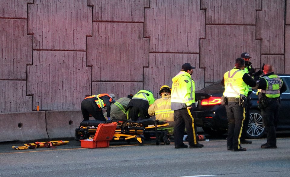 Emergency crews assist a pedestrian struck by a vehicle on Highway 1 near the Grandview Highway exit Friday morning.