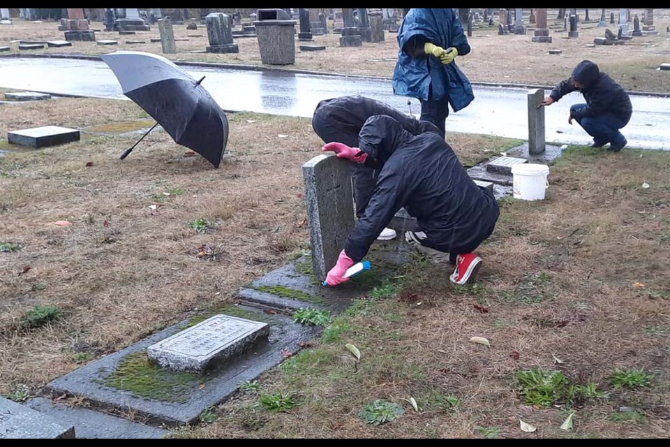 Scouts, Guides, schoolchildren and parents joined the Officers of the Honourable Guard at New Westminster's Fraser Cemetery on Sunday to clean war graves — on a day that featured cold rain, wind and snow.
