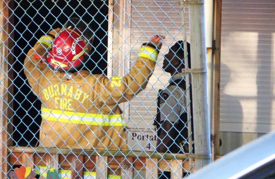 A firefighter and RCMP officer respond to reports of a fire at Burnaby's Cameron Elementary School.                        