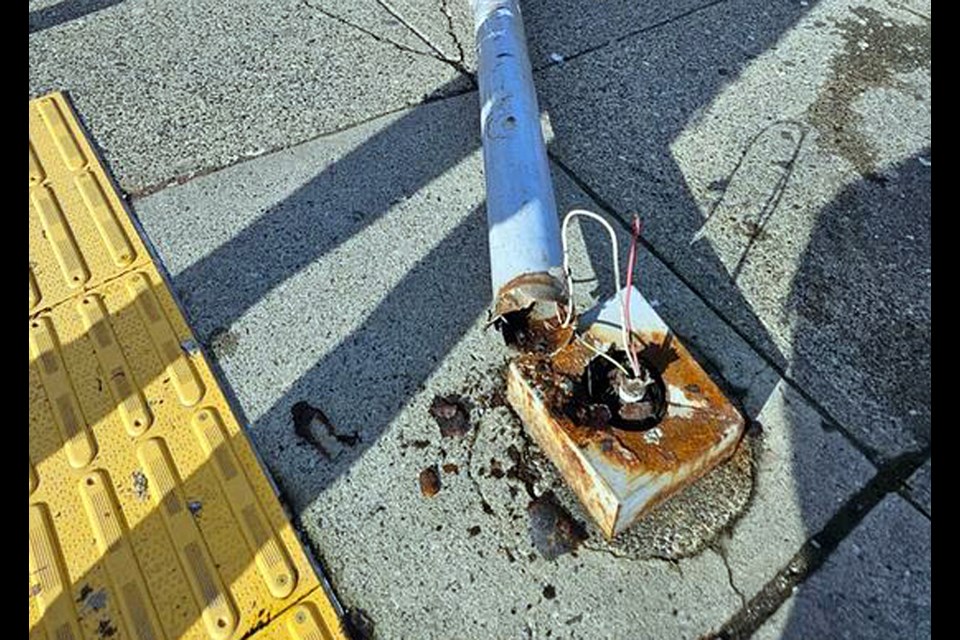 A light pole with a rusted based fell on a vehicle and a woman outside the Edmonds SkyTrain station Sunday.