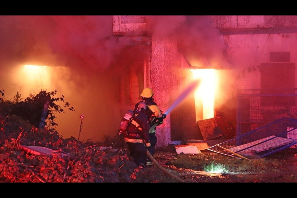 New Westminster firefighters battle a blaze that broke out in an abandoned apartment building on Cariboo Street on the morning of Dec. 23, 2020.