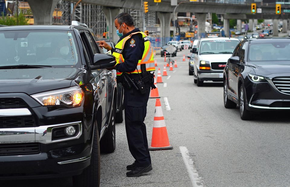 An Integrated Road Safety Unit officer pulls over a motorist during a traffic enforcement blitz on Lougheed Highway in Burnaby Monday.