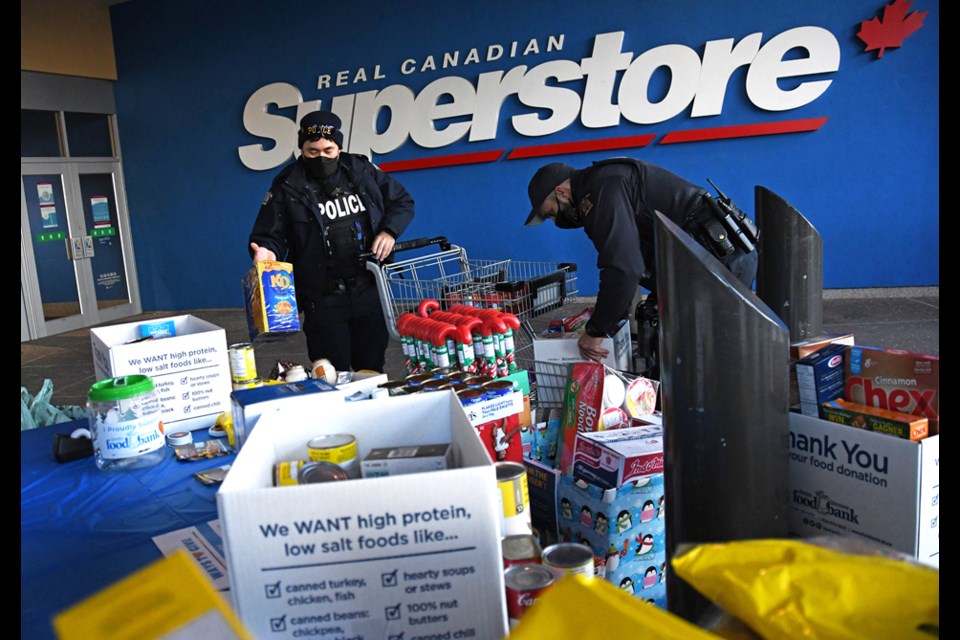 Burnaby Mounties sort donations during a Cram the Cruiser food drive in Metrotown Friday.