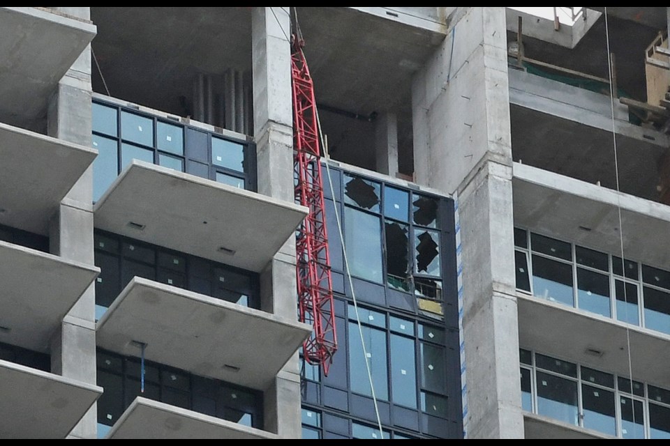 A section of construction crane dangles off a highrise under construction in Burnaby's Brentwood area.