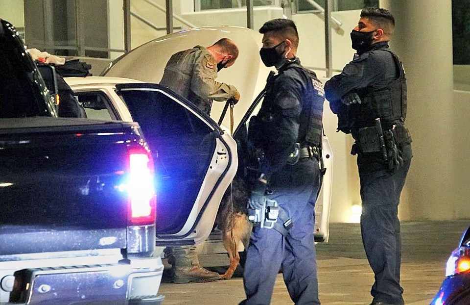 A dog team searches a vehicle stopped by Burnaby RCMP's gang team Sunday.