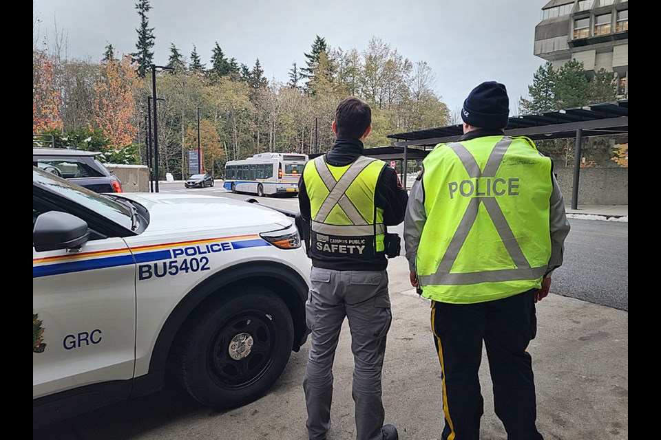 A Burnaby Mountie and a member of SFU's traffic safety team watch for traffic violations at an SFU bus loop.