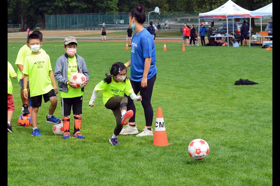 A player sends the ball toward goal at the Burnaby RCMP youth soccer camp at Confederation Park Tuesday.