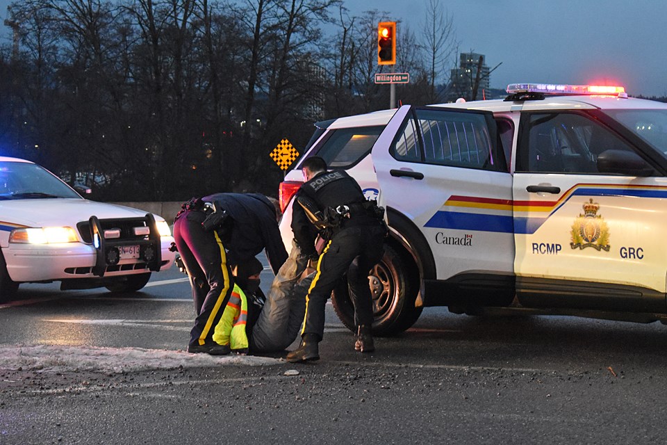 An anti-logging demonstrator is arrested at the Willingdon Avenue off-ramp in Burnaby Monday.