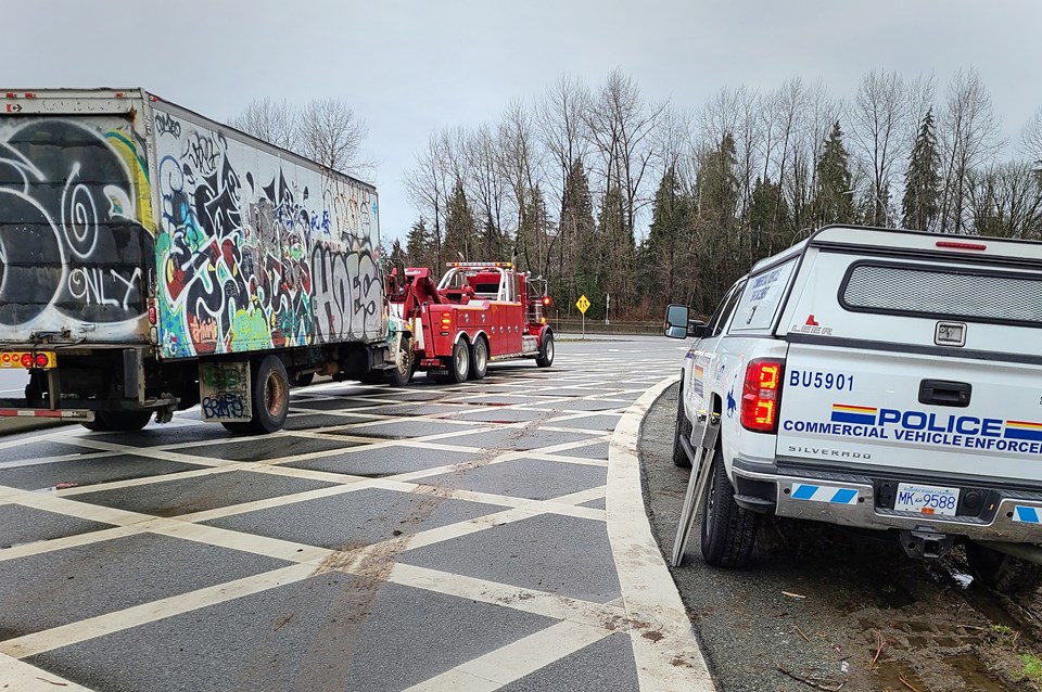 A box truck with bald tires and no brake lights is towed on the Gaglardi Way off ramp by Highway 1 in Burnaby.