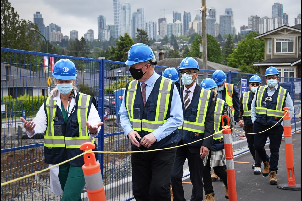 B.C. Premier John Horgan (centre) and Dr. Sarah Ostler (left), Burnaby Hospital's site medical director, discuss the redevelopment of Burnaby Hospital on May 30, 2022.