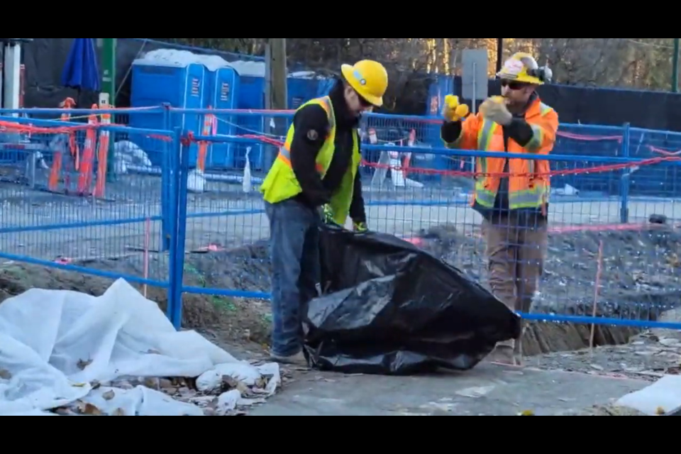 Trans Mountain workers pick up rubber ducks found on a pipeline construction site in Burnaby, B.C., on Nov. 28.