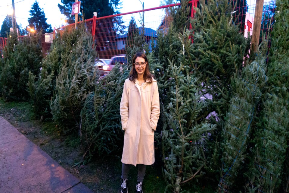 Dianna stands at one of Aunt Leah’s Tree Lots. Dianna is a former participant who likes to remain connected to the organization. 