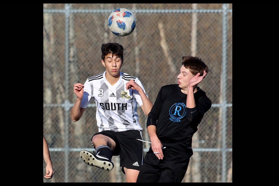 Burnaby South Rebels defender Santiago Valenzuela (left) wins a header against a Reynolds forward in the first half of their second round match at the 2023 BC Secondary Schools AAA senior boys' soccer provincials on Thursday, Nov. 23, at the Burnaby Lake Sports Complex West.
