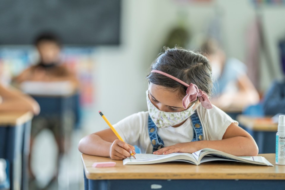 Masked student in classroom
